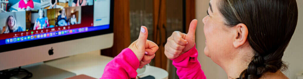 Mobilates member on a video call giving two thumbs up to the group