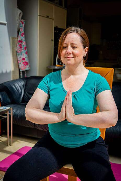 mob member Alex taking part in an online class with her hands together in meditation