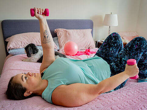 instructor leanne using dumbbells while lying in bed