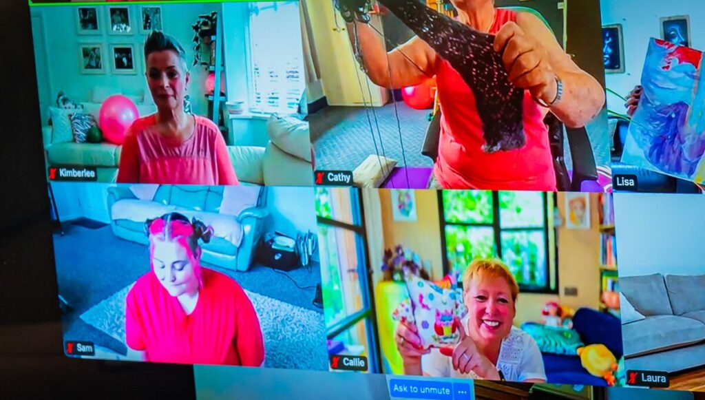 A screen showing a cheerful online video call with several people joining from their homes.