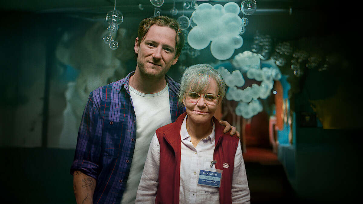 Tova and Cameron standing together in front of an aquarium tank with jellyfish